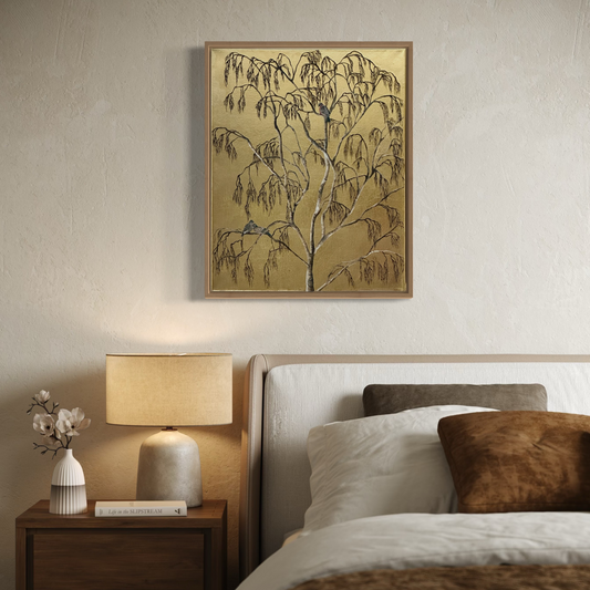 gold leaf artwork of silver birch branches and stock doves. Framed in light wood and hanging above a calm earthy toned bedroom setting 