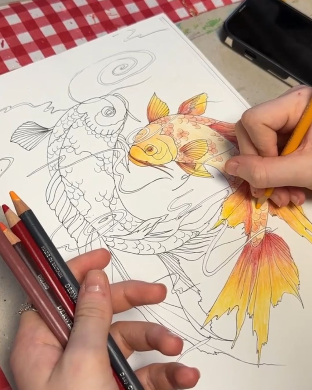 Work-in-progress photo of a student colouring the geisha illustration using pencils